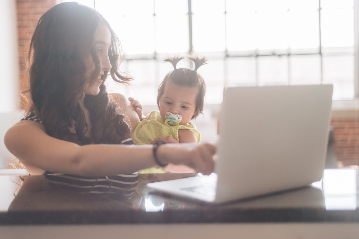 Mommy showing baby how she works on her laptop